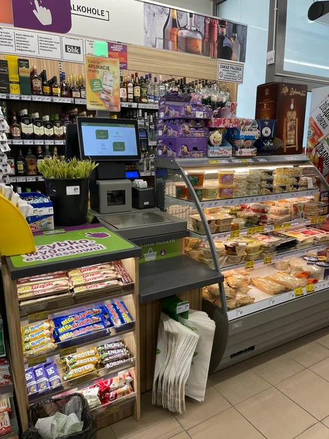 Interiér samoobslužné prodejny s pokladnou.